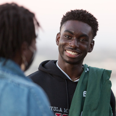 An LMU student on campus talking to a peer.